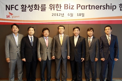 SK플래닛과 관계자들의 MOU 기념사진입니다. 현수막에 NFC 활성화를 위한 비즈 파트너쉽 협력식이라고 적혀있습니다.