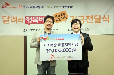 기금 전달식에서 관계자들이 기념 사진을 촬영하고 있습니다. 현수막에는 달려라 행복버스 기금 전달식이라고 적혀 있고 배너에는 저소득층 교통지원금 3천만원이라고 적혀있습니다.