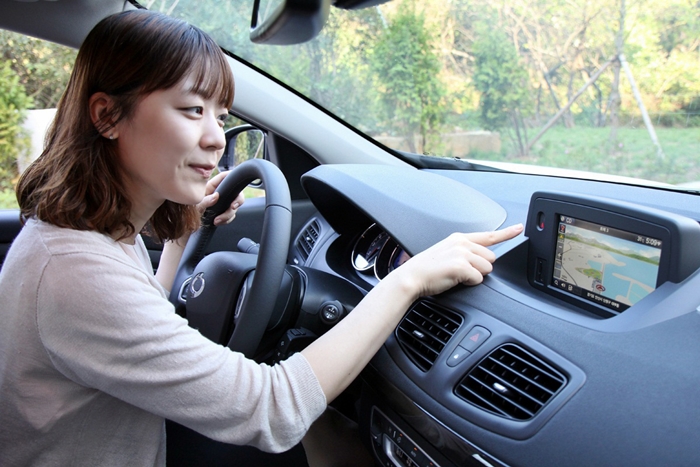 SK플래닛, 차량용 인포테인먼트 플랫폼 상용 서비스 홍보 사진입니다 모델이 자동차 안에서 기기를 조작하고 있습니다.