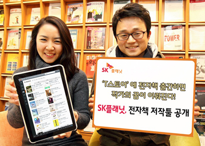 왼쪽 모델은 앱 구동화면을 들고 있고 오른쪽 모델은 T스토어에 전자책 출간하면 작가의 꿈이 이뤄진다.SK플래닛, 전자책 저작툴 공개라고 적힌 배너를 들고 있습니다.