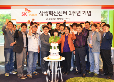 SK플래닛, 상생혁신센터 개소 1주년 기념사진입니다. 현숙막에 상생혁신센터 1주년 기념이라고 적혀있습니다.