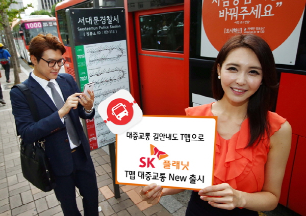 SK플래닛, ‘T맵 대중교통 New’ 출시 홍보 사진입니다. 왼쪽 모델은 앱을 사용하고 있고 오른쪽 모델은 대중교통 길안내도 T맵으로 SK플래닛 T맵 대중교통 NEW 출시 배너를 들고 있습니다.