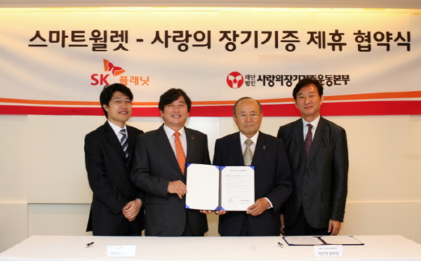 SK플래닛 스마트월렛, 생명나눔 위한 사랑의 장기기증운동 제휴 협약식 사진입니다. 각 회사의 관계자들의 기념사진이 삽입되어 있습니다. 현수막에는 스마트 월렛-사랑의 장기기증 제휴 협약식이라는 문구가 적혀있습니다.