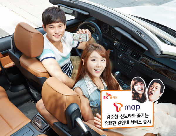 T맵, 김준현과 신보라와 즐기는 유쾌한 길안내 서비스 출시 이벤트 홍보 사진입니다. 왼쪽 모델은 앱 구동화면을 들고 있으며, 오른쪽 모델은 T맵 김준현, 신보라와 즐기는 유쾌한 길안내 서비스 출시라고 적힌 배너를 들고 있습니다. 