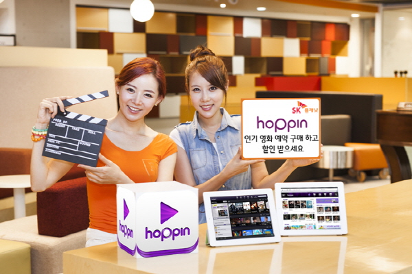 SK플래닛 호핀, 영화 VOD 예약 구매 할인 서비스 제공 홍보 사진입니다. 왼쪽 모델은 슬레이트를 들고 있고 오른쪽 모델은 호핀 인기 영화 예약 구매하고 할인 받으세요 라고 적힌 배너를 들고 있습니다. 그리고 앞에는 호핀 앱 아이콘과 앱 구동화면이 놓여 있습니다.