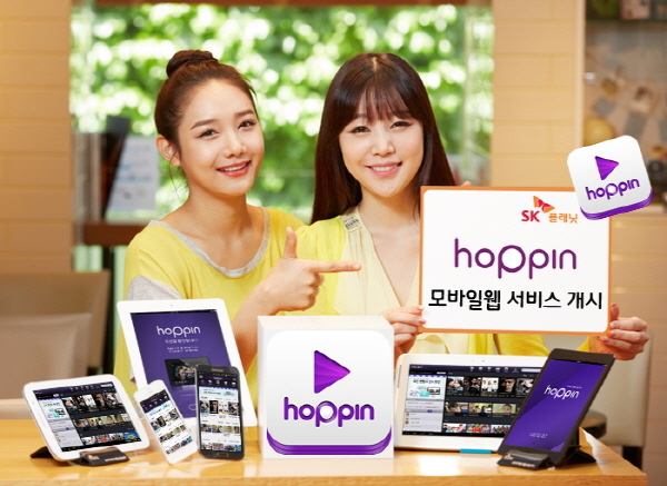 SK플래닛, 호핀 모바일웹 서비스 개시 관련 홍보사진입니다. 왼쪽 모델은 오른쪽 모델이 들고 있는 HOPPIN 모바일 웹 서비스 개시라고 적힌 배너를 가리키고 있습니다.