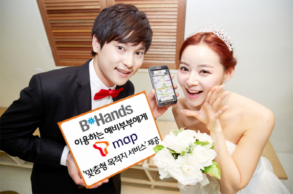 SK플래닛 T맵-청첩장 업계 1위 비핸즈,청첩장 용 ‘맞춤형목적지서비스’ 제공 홍보사진입니다. 왼쪽 모델은 비핸즈 이용하는 예비부부에게 T맵 맞춤형 목적지 서비스 제공이라고 적힌 배너를 들고 있습니다.