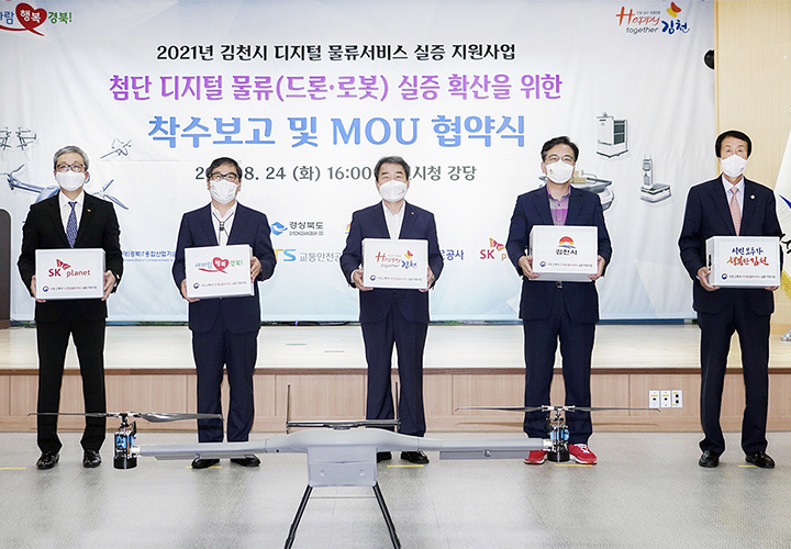 SK플래닛이 2021년 김천시 디지털 물류서비스 실증 지원사업을 위한 첨단 디지털 물류 실증 확산을 위한 착수보고 및 MOU 협약식의 단체사진이 삽입되어 있습니다.